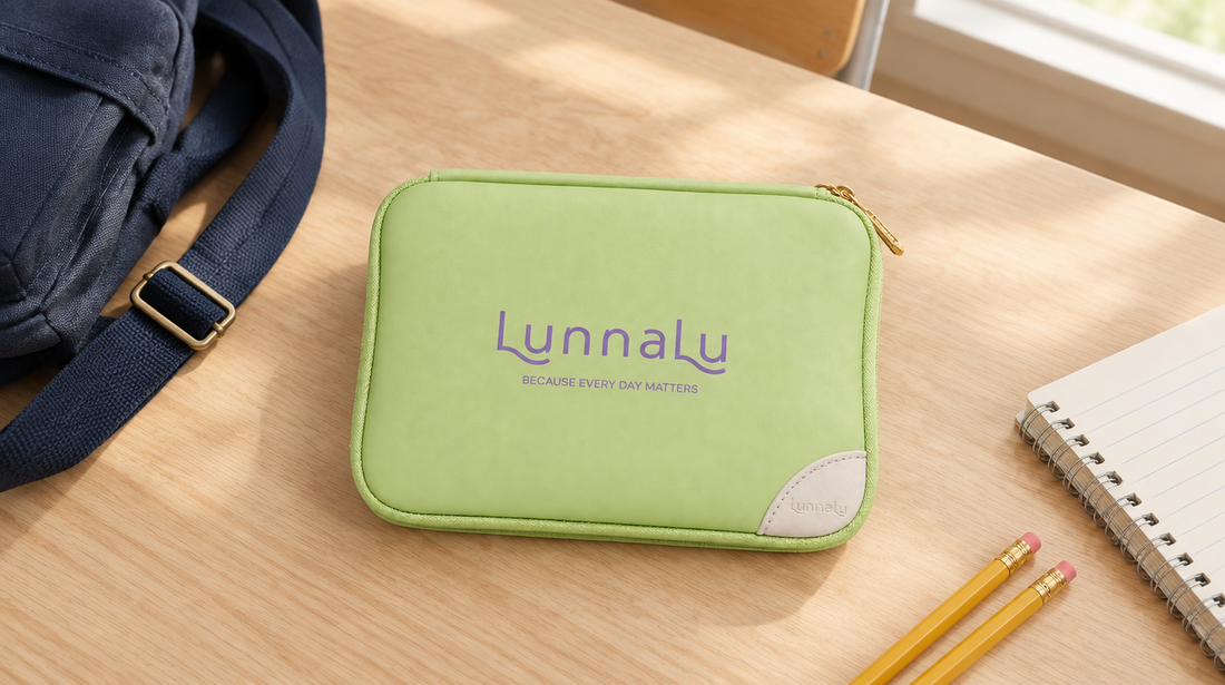 A period kit for school lying flat on a desk beside a backpack strap, exercise book and pencils